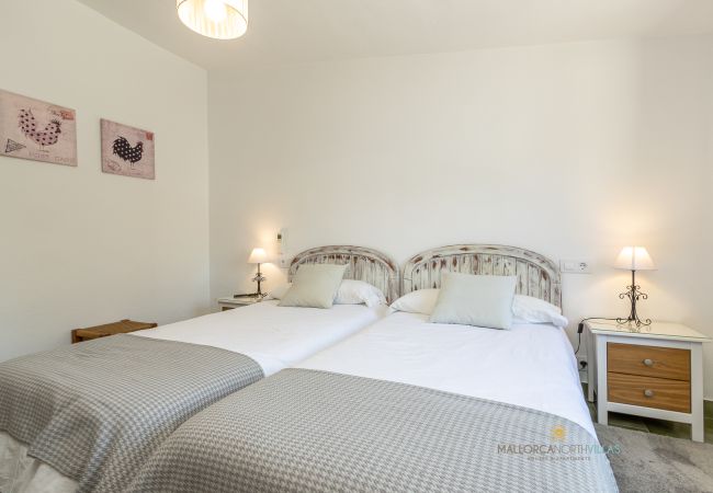 Dormitorio doble de La Sort Llarga – Dos camas en Pollença Dormitorio con dos camas individuales y decoración acogedora en La Sort Llarga, Pollença