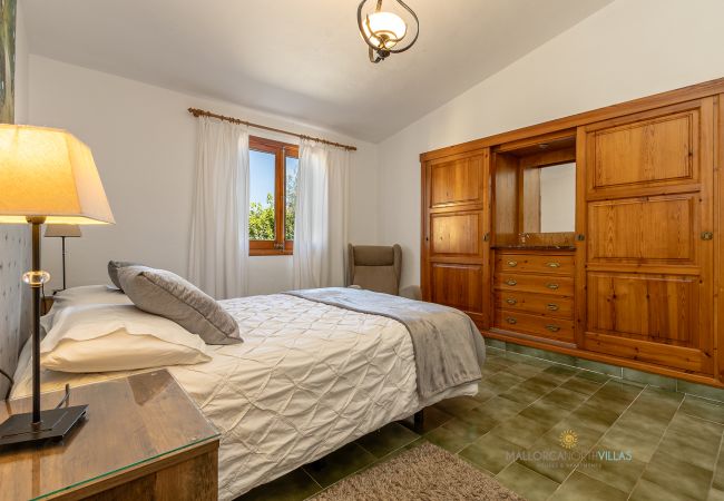 Dormitorio La Sort Llarga – Cama doble y armario en Pollença Habitación con cama doble, armario de madera y ventana en La Sort Llarga, Pollença