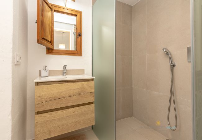 Baño de La Sort Llarga – Ducha y lavabo en Pollença Baño con ducha y mueble de lavabo de madera en La Sort Llarga, Pollença