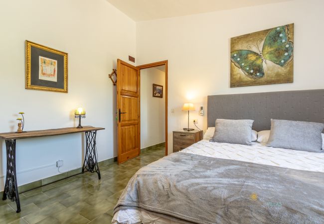 Dormitorio La Sort Llarga – Cama doble y consola en Pollença Habitación con cama doble, mesitas de noche, cuadro y consola en La Sort Llarga, Pollença