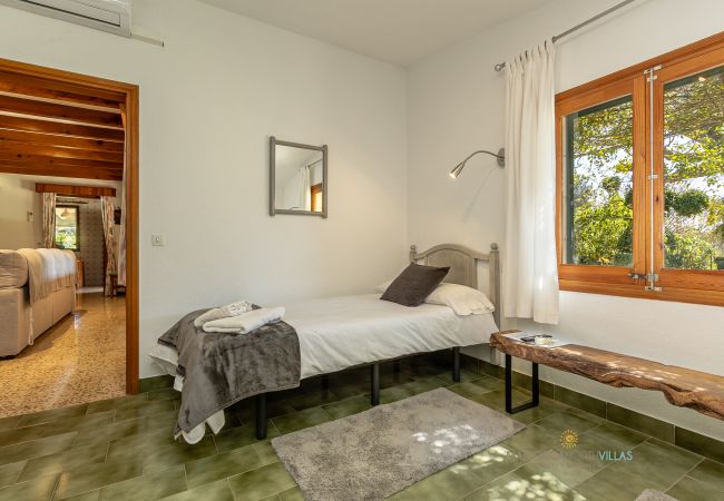 Dormitorio individual La Sort Llarga – Habitación en Pollença Dormitorio con cama individual y ventana al jardín en La Sort Llarga, Pollença