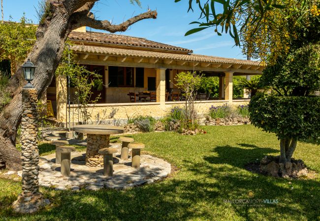 Exterior de La Sort Llarga – Jardín y terraza en Pollença Jardín con mesa de piedra y terraza cubierta en la villa La Sort Llarga, Pollença, Mallorca