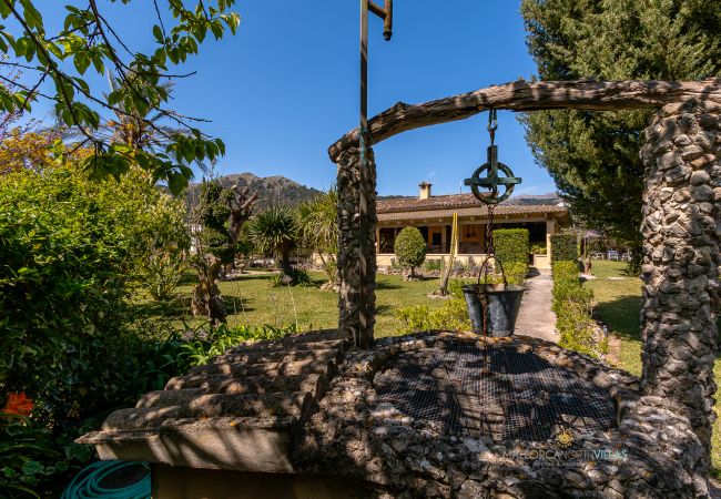 Pozo de piedra y jardín en La Sort Llarga Pollença Pozo rústico y fachada de la finca La Sort Llarga, Mallorca