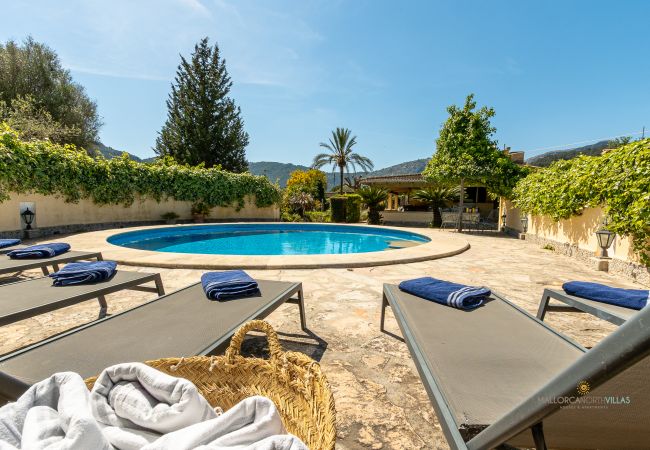 Piscina con tumbonas de La Sort Llarga en Pollença Piscina privada redonda con varias tumbonas y toallas listas para los huéspedes en La Sort Llarga, Pollença