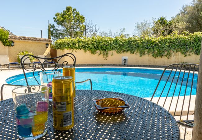 Mesa con bebidas junto a la piscina de La Sort Llarga Vistas de la piscina privada de La Sort Llarga en Pollença con una mesa preparada para disfrutar de una bebida al aire libre