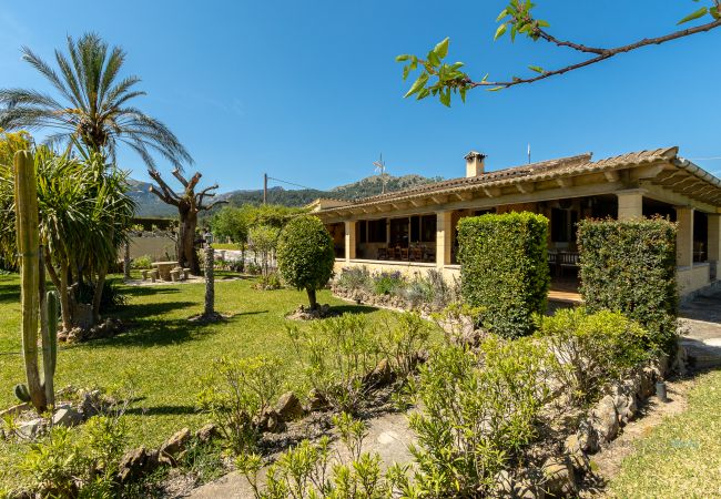 Exterior de La Sort Llarga – Jardín mediterráneo en Pollença Jardín con terraza cubierta y vegetación en la villa La Sort Llarga, Pollença
