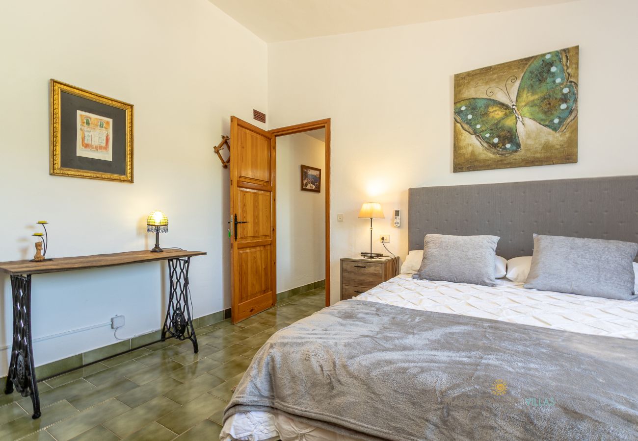 Dormitorio La Sort Llarga – Cama doble y consola en Pollença Habitación con cama doble, mesitas de noche, cuadro y consola en La Sort Llarga, Pollença