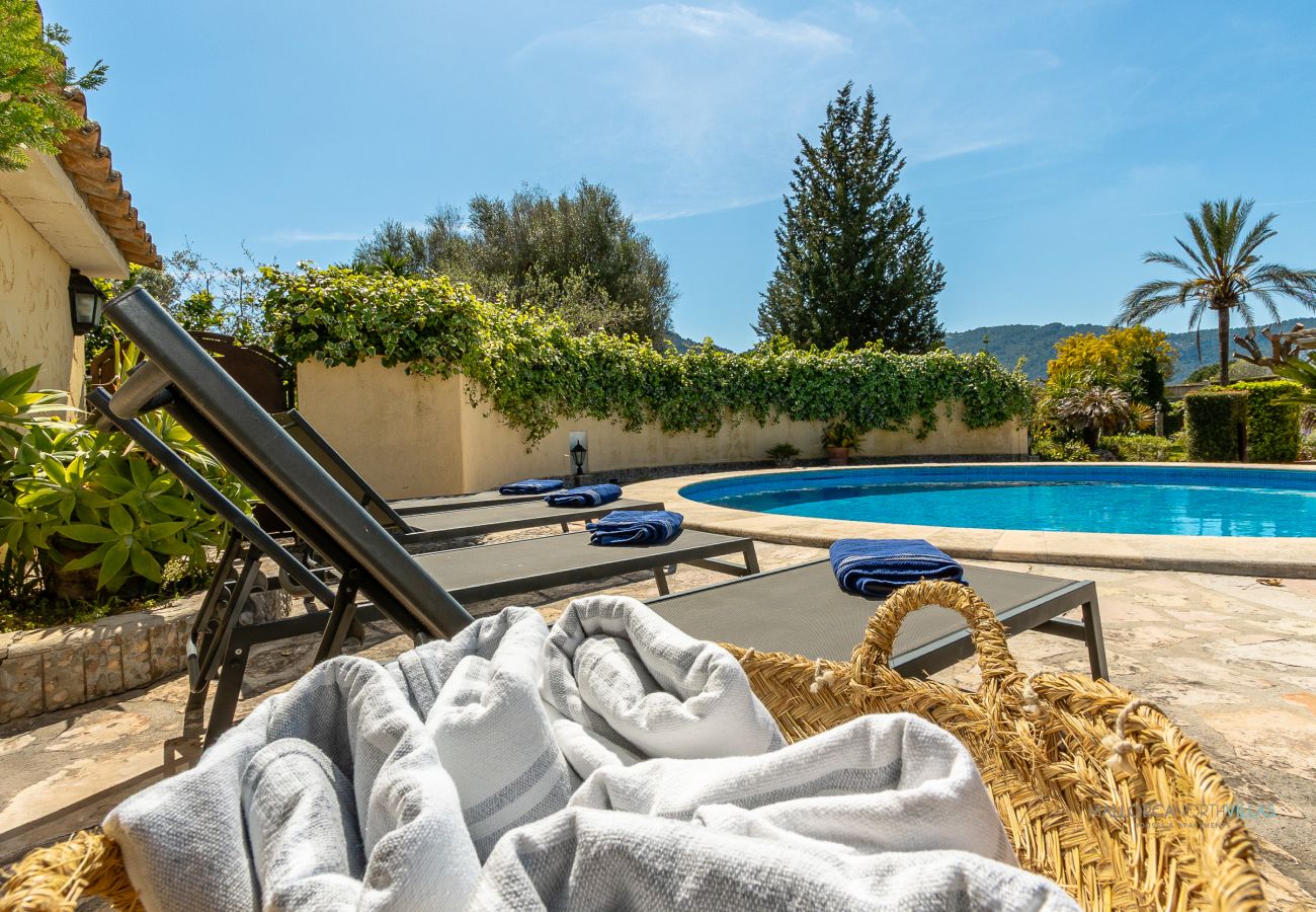 Piscina con tumbonas de La Sort Llarga en Pollença Piscina privada redonda con varias tumbonas y toallas listas para los huéspedes en La Sort Llarga, Pollença