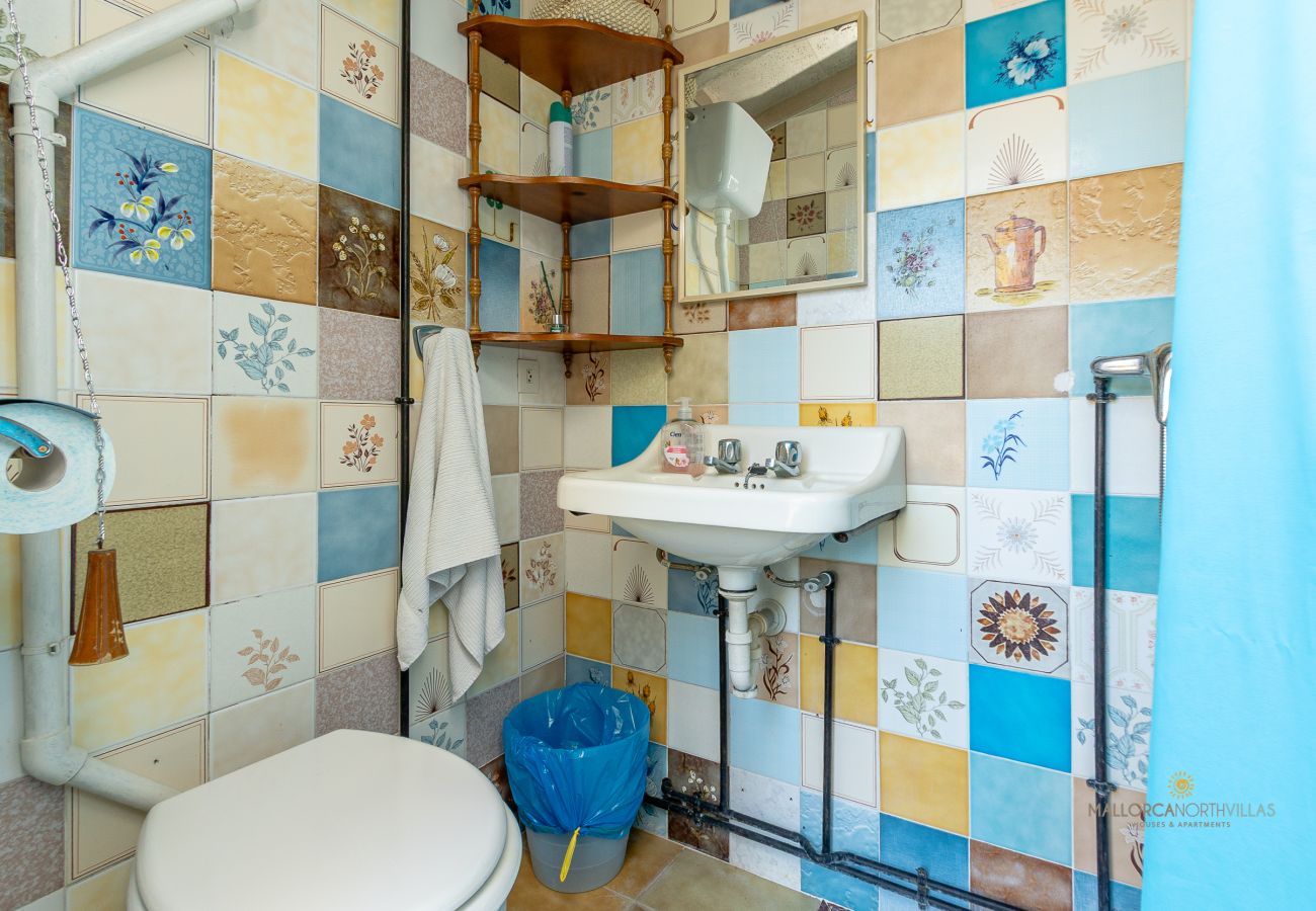 Baño con ducha y azulejos de colores en La Sort Llarga, Pollença Baño con sanitario, lavabo y ducha en La Sort Llarga, Pollença