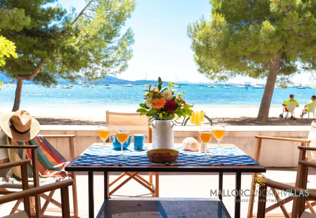 Terraza con vistas al mar, ideal para desayunos o cenas al aire libre Terraza privada con sillas de madera y mesa, vistas al mar y barcos en la bahía.