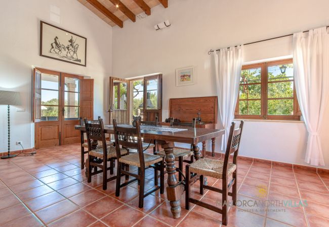 Rustikales Esszimmer mit Holztisch und Terrassenzugang Esszimmer mit Holztisch, hohen Decken und Terrassenzugang in Ferienfinca Mallorca