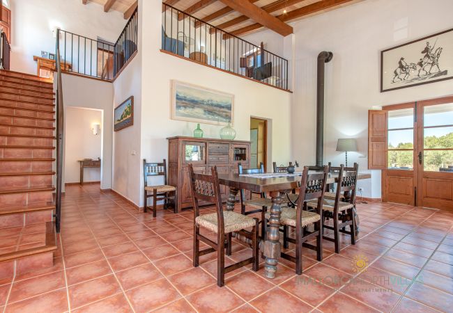 Rustikales Esszimmer mit Treppe und Terrassenzugang Esszimmer mit Holztisch, Treppe ins Obergeschoss und Terrassenzugang in Ferienfinca Mallorca