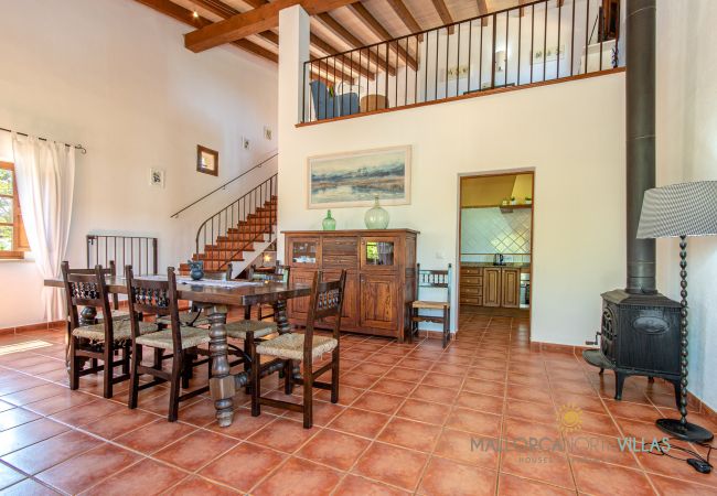 Rustikales Esszimmer mit Holzofen in der Finca Esszimmer mit Holztisch, Holzofen und hohen Decken in Ferienfinca Mallorca