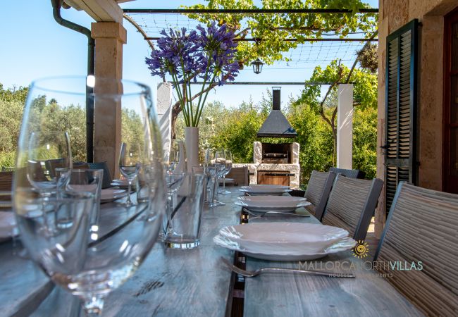 Terrasse mit Essbereich und Grill in Mallorca Finca Gedeckter Esstisch auf Terrasse mit gemauertem Grill in Ferienfinca Mallorca