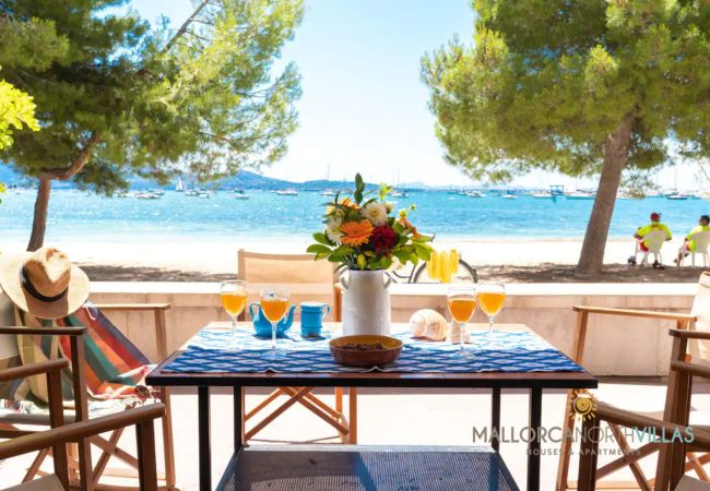 Terrasse mit Meerblick, ideal für Mahlzeiten im Freien Private Terrasse mit Holzstühlen und Tisch, mit Blick auf das Meer und Boote in der Bucht.