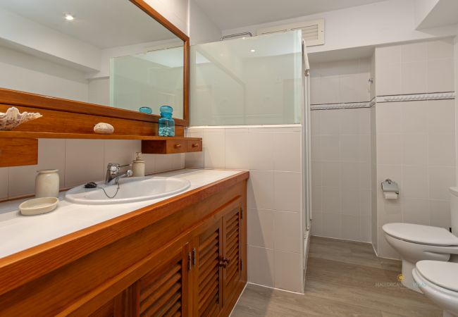 Bad mit Dusche – Ferienwohnung Bel Mallorca Badezimmer mit Dusche, Waschbecken und Holzschrank in der Ferienwohnung Bel by Mallorca North Villas
