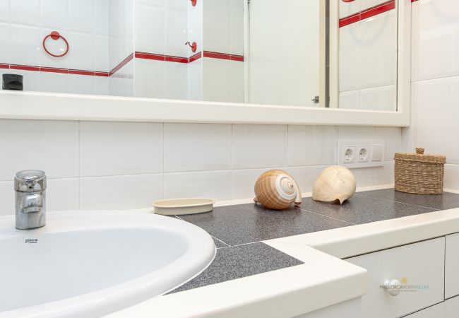 Modernes Badezimmer der Ferienwohnung Bel auf Mallorca Badezimmer mit Waschbecken, Spiegel und dekorativen Details in der Ferienwohnung Bel by Mallorca North Villas