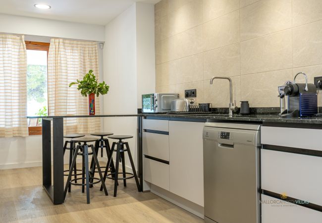 Moderne, voll ausgestattete Küche Küche mit Theke und Hockern, Geschirrspüler und Kleingeräten.