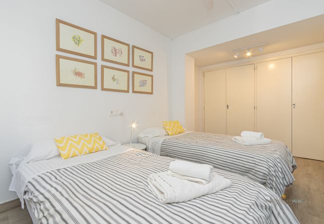 Schlafzimmer mit zwei Betten und großem Einbauschrank Zimmer mit zwei Einzelbetten, dekorativen Kissen und großem Einbauschrank.