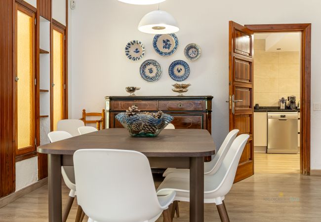 Esszimmer mit Zugang zur Küche Esstisch mit sechs weißen Stühlen, antikem Sideboard und Eingang zur Küche.