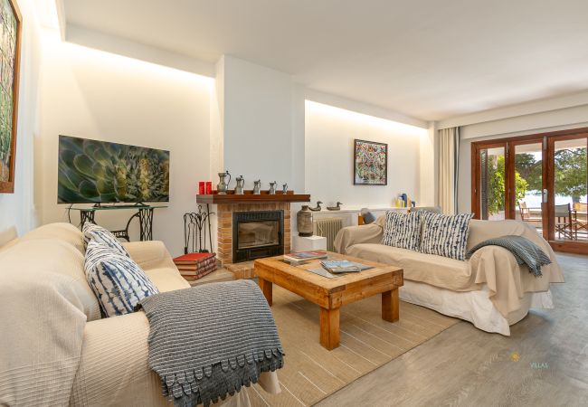 Helles Wohnzimmer mit Kamin und Zugang zur Terrasse Wohnzimmer mit zwei Sofas, Holztisch, Kamin und Zugang zur Terrasse.