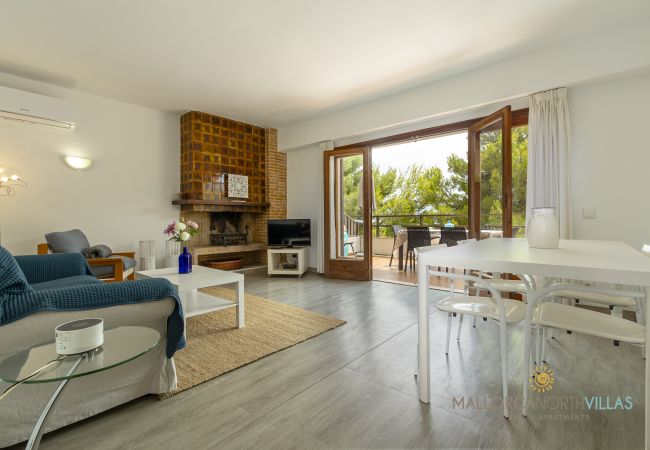 Wohnzimmer mit Kamin und Terrassenzugang Wohnzimmer mit blauem Sofa, Kamin und offenen Terrassentüren