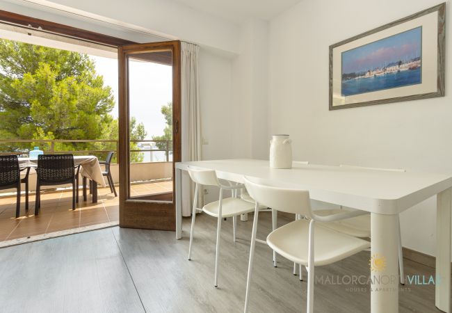 Essbereich mit Zugang zur Terrasse Weißer Esstisch neben offenen Türen zur Terrasse