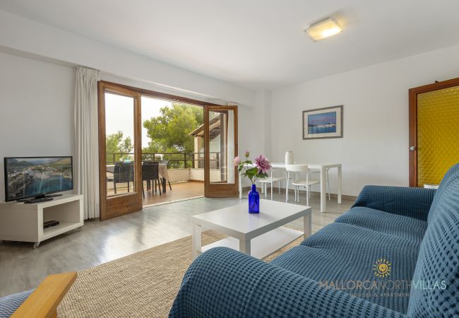 Wohnzimmer mit Terrassenzugang Wohnzimmer mit blauem Sofa und offenen Türen zur Terrasse