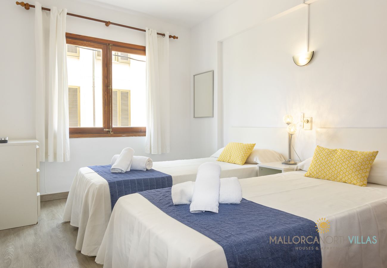 Helles Twin-Schlafzimmer Zwei Einzelbetten mit blauen Läufern und gelben Kissen