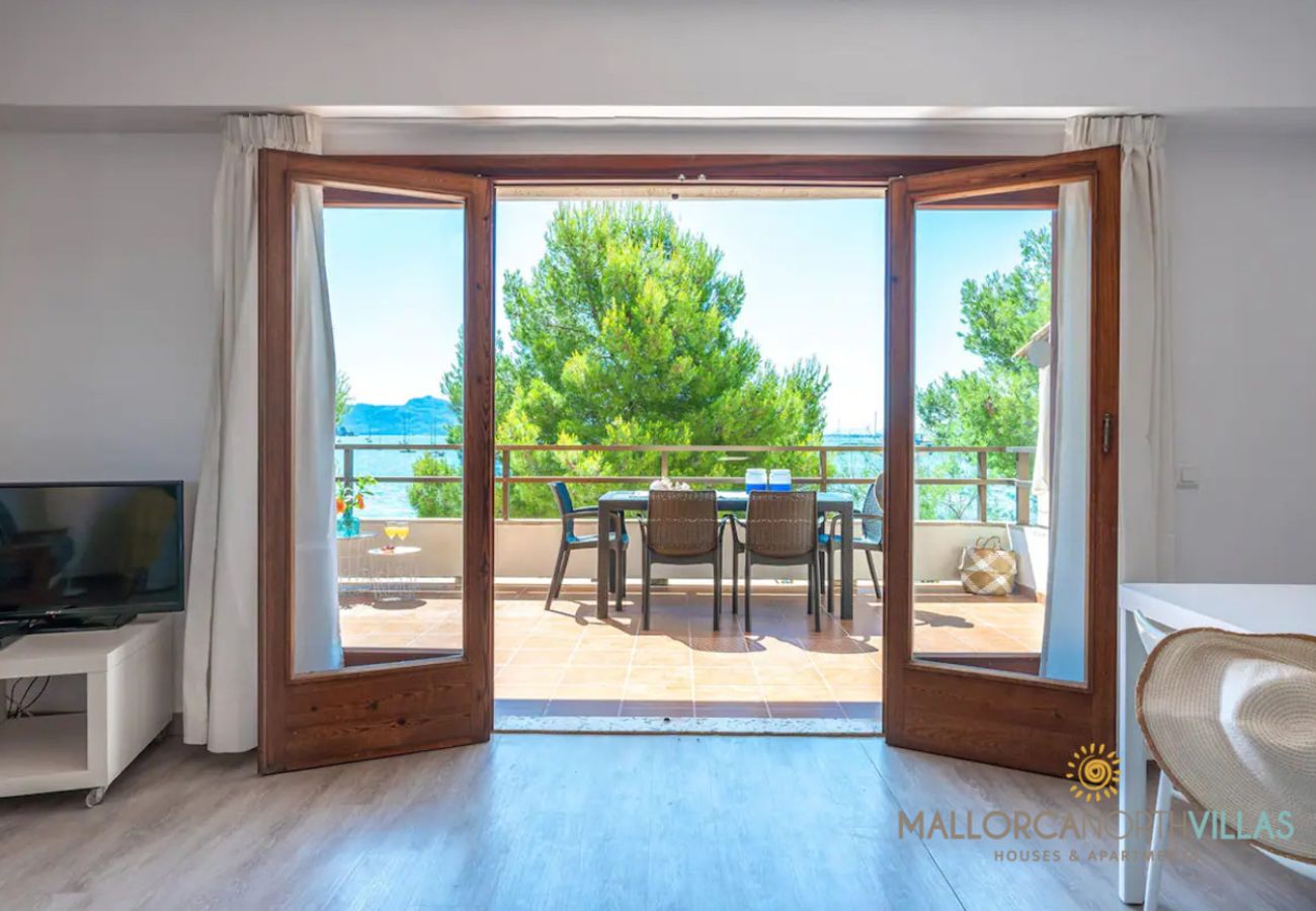 Wohnzimmer mit Terrasse und Blick – Puerto Pollensa Helles Wohnzimmer mit offenen Türen zur Terrasse und Meerblick in der Ferienwohnung Bel, Puerto de Pollensa, Mallorca