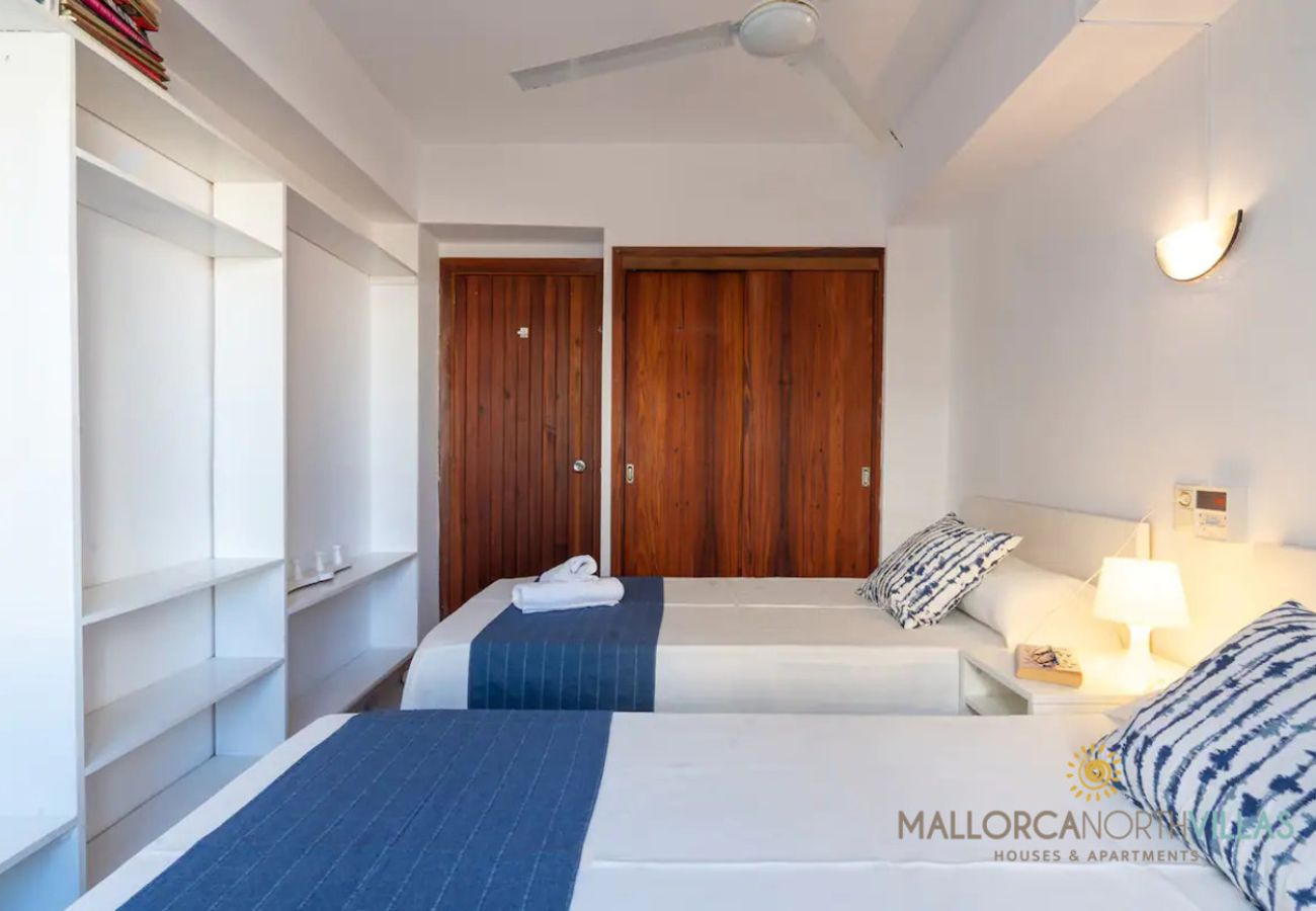 Twin-Schlafzimmer mit Deckenventilator Zwei Einzelbetten mit blauen Läufern und Holzschränken