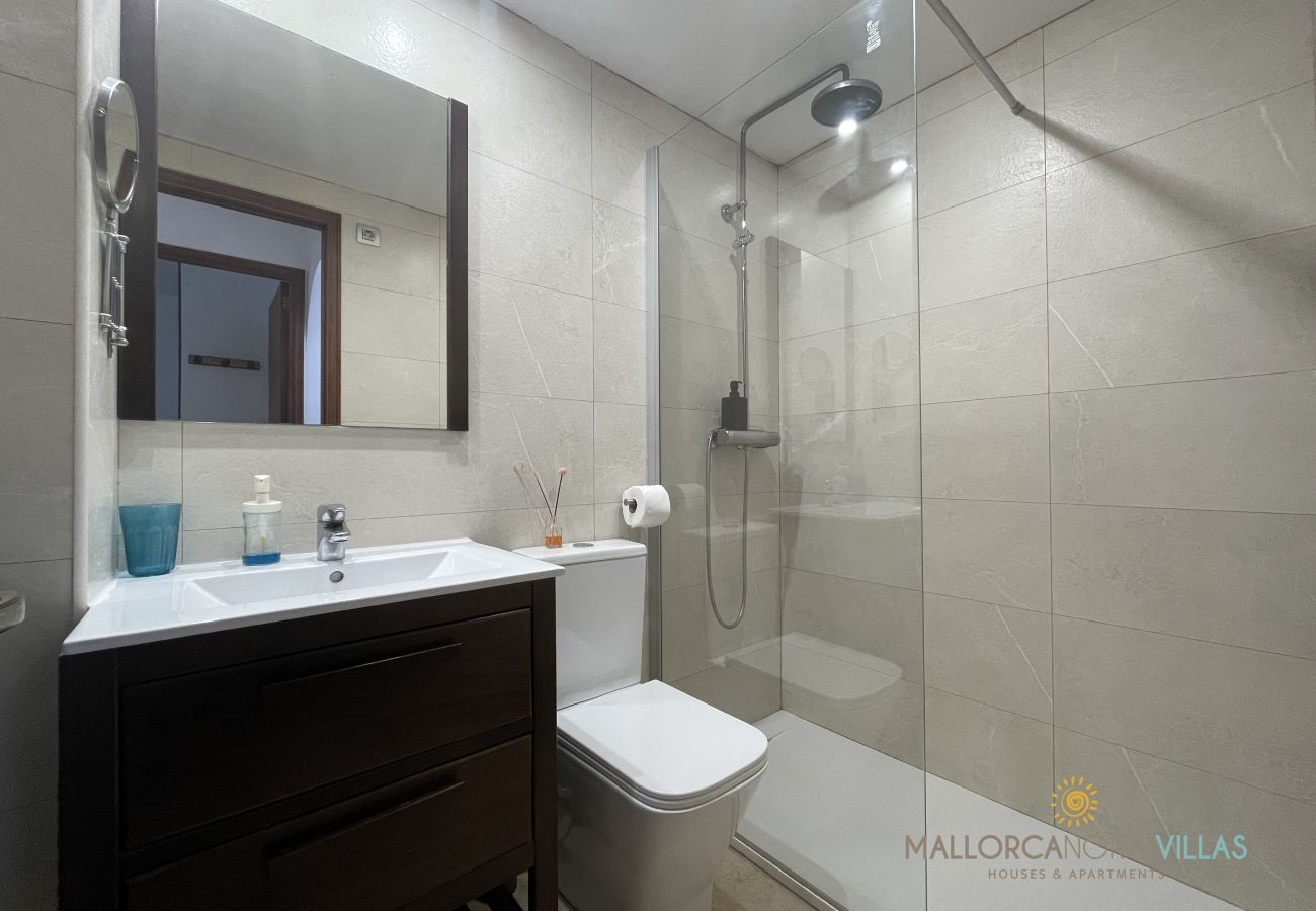 Modernes Badezimmer mit Glasdusche in Mallorca North Villas Modernes Badezimmer mit Glasdusche, Toilette und Waschtisch in einer Immobilie von Mallorca North Villas.