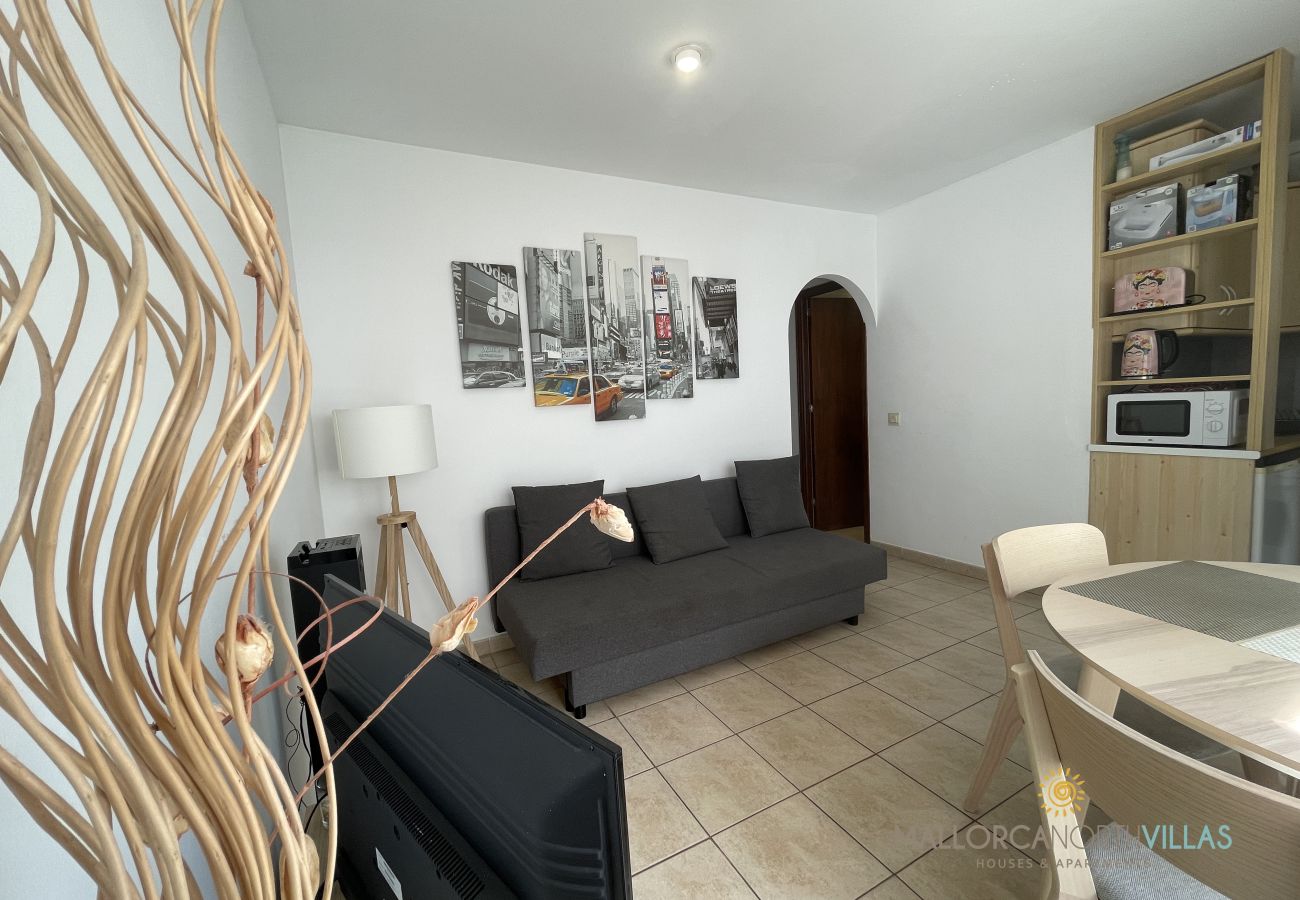 Living-dining room with sofa bed and modern decor Living-dining room with sofa bed, dining table, TV, and modern decor featuring New York artwork.