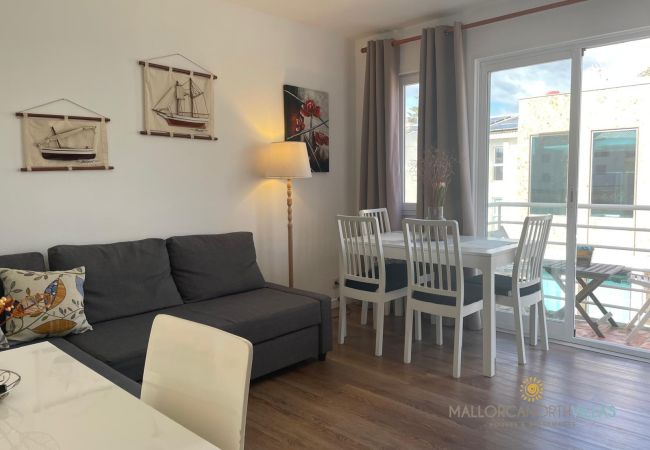 Cozy Living-Dining Room with Nautical Decor Living-dining room with a gray sofa, white table, chairs, and nautical decorations on the wall.