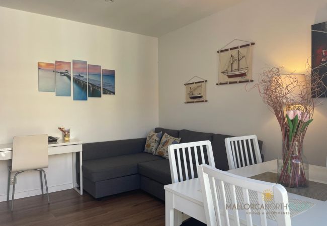 Cozy Living-Dining Room with Nautical Decor Living-dining room with a gray sofa, white table, chairs, and nautical decorations on the wall