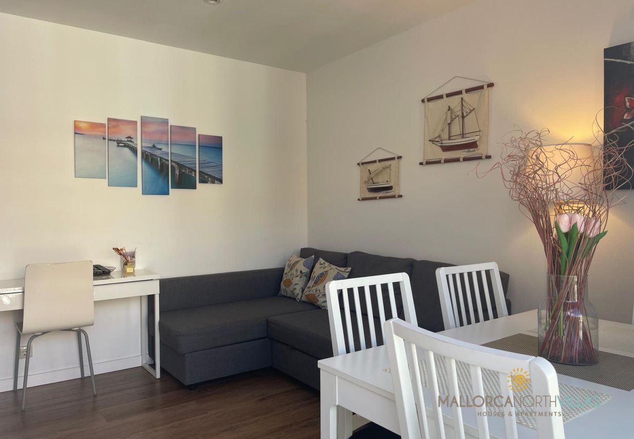 Cozy Living-Dining Room with Nautical Decor Living-dining room with a gray sofa, white table, chairs, and nautical decorations on the wall