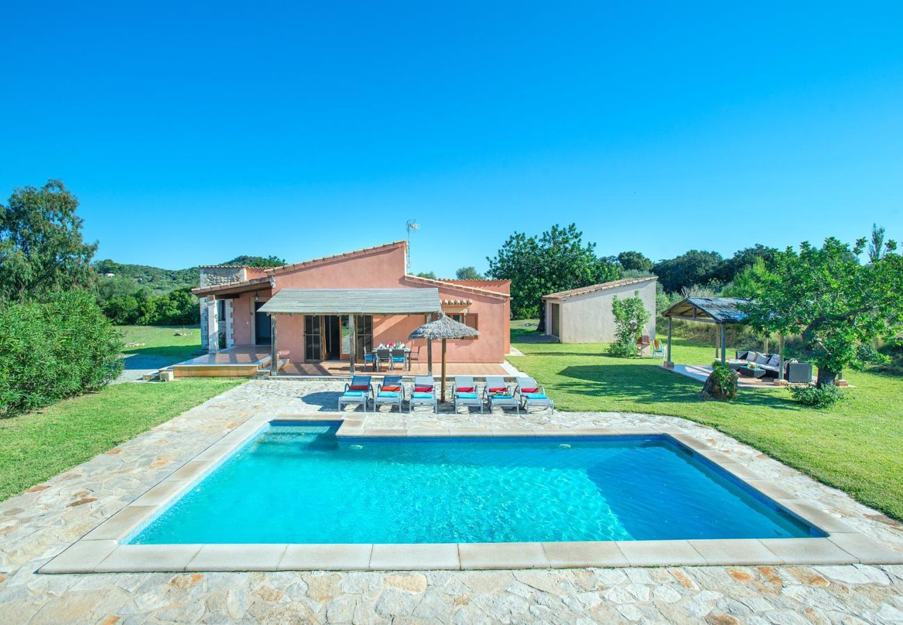 View of the country house with private pool, sunbathing area and large garden surrounded by nature in Mallorca.